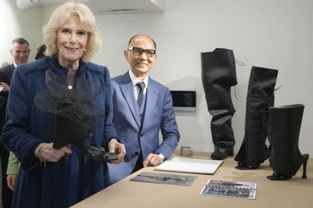 The Queen Consort an item of footwear made from sustainable cacti leather during a visit to the JCA London Fashion Academy, in Brentford, west London, to meet co-founders Jimmy Choo and Stephen Smith (Kirsty Wigglesworth/PA)