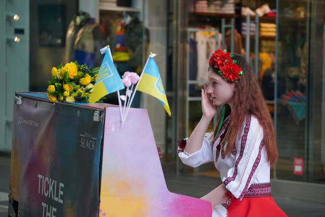 Ukrainian teenager, Alisa Bushuieva, who was forced to flee her country with her mother, Svitlana, in February last year, plays the piano in Liverpool ONE shopping centre to mark a year since the Russian invasion (Peter Byrne/PA)