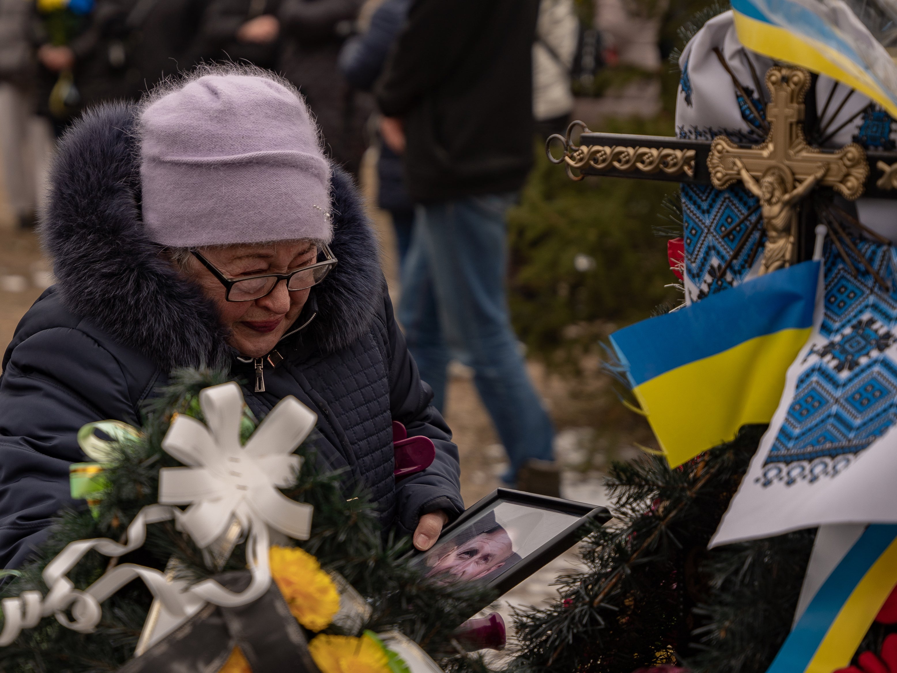 An elderly resident of Bakhmut cries as she marks the anniversary of Russia’s invasion of Ukraine