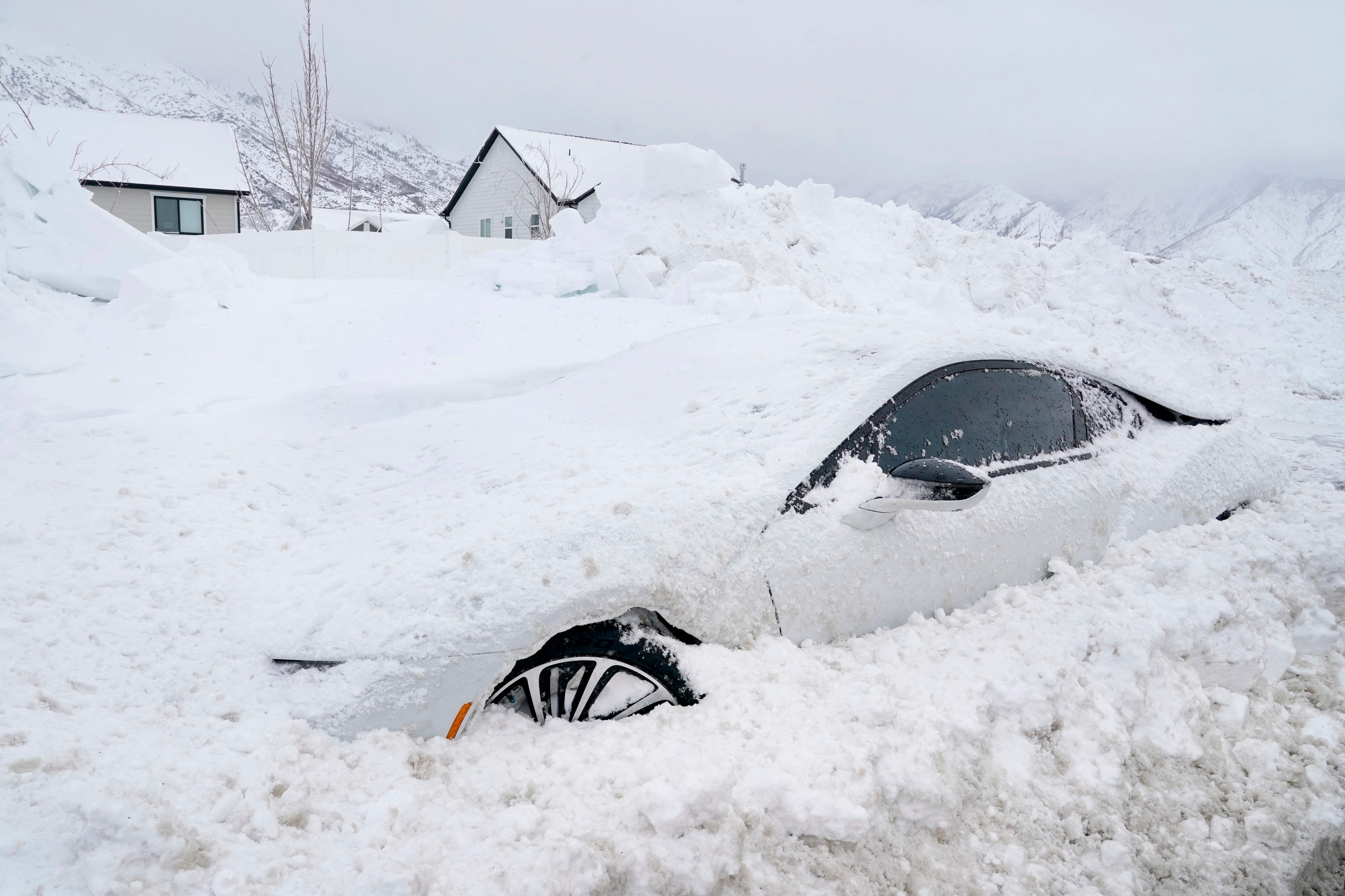 An abandoned electric car is buried in snow in Draper, Utah, on February 23, 2023