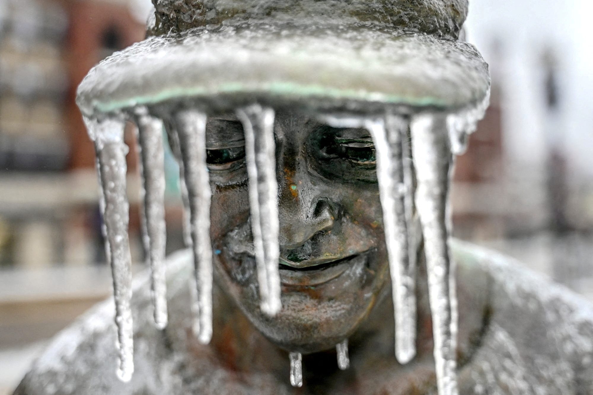 Icicles hang from the hat of a figure that is part of the Hometown Hero baseball sculpture outside Jackson Field in Lansing, Michigan on February 23