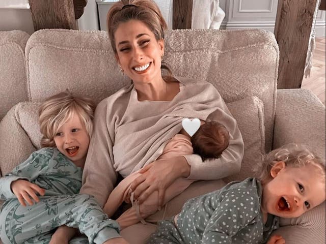 <p>Stacey Solomon breastfeeds baby Belle while her other two children, Rex and Rose, cuddle with her</p>