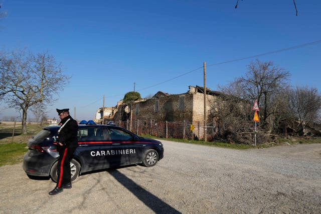 <p>A policeman patrols near the crumbling farmhouse where the body of Saman Abbas was found</p>