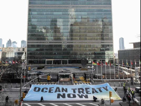 Greenpeace USA activists unfurl a giant banner to send a message to delegates at the United Nations in New York