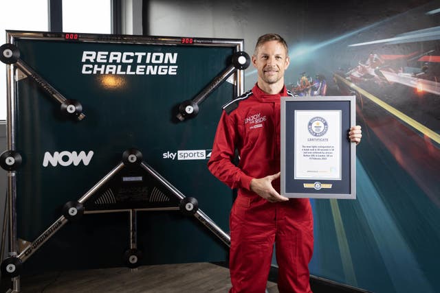 Formula 1 driver Jenson Button is presented with a Guinness World Records certificate after breaking the record for ‘the most lights extinguished on a Batak wall in 30 seconds’, achieving a score of 58 lights extinguished. (Matt Alexander/PA)