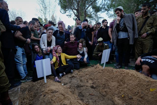 <p>Family members and friends of Hillel Yaniv, 21, and Yagel Yaniv, 19, mourn over their graves during their funeral at Israel's national cemetery in Jerusalem</p>