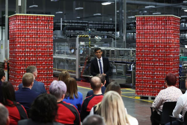 Prime Minister Rishi Sunak flanked by towers of Coca-Cola (Liam McBurney/PA)