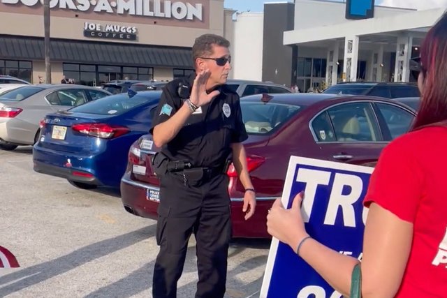 <p>A police officer speaking to Trump supporters outside the book signing event</p>