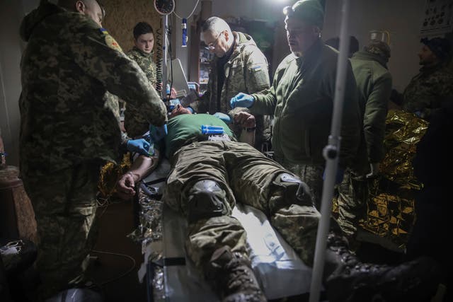<p>Medics give the first aid to a wounded Ukrainian soldier near Bakhmut, the site of the heaviest battles with the Russian troops, Donetsk region, Ukraine, Monday, 27 February 2023</p>