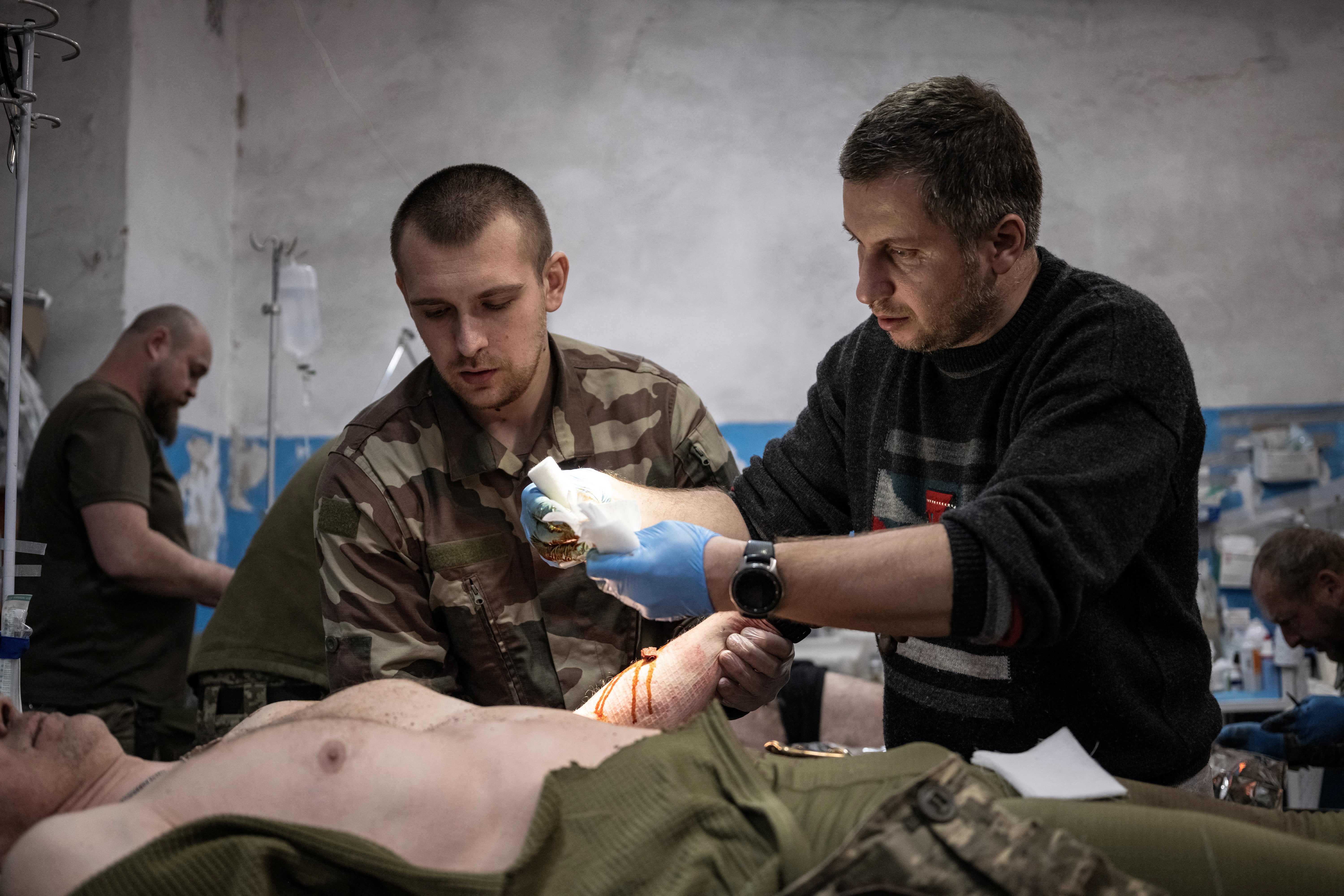 General practitioner Volodymyr and general surgeon Yuri treat a wounded Ukrainian soldier