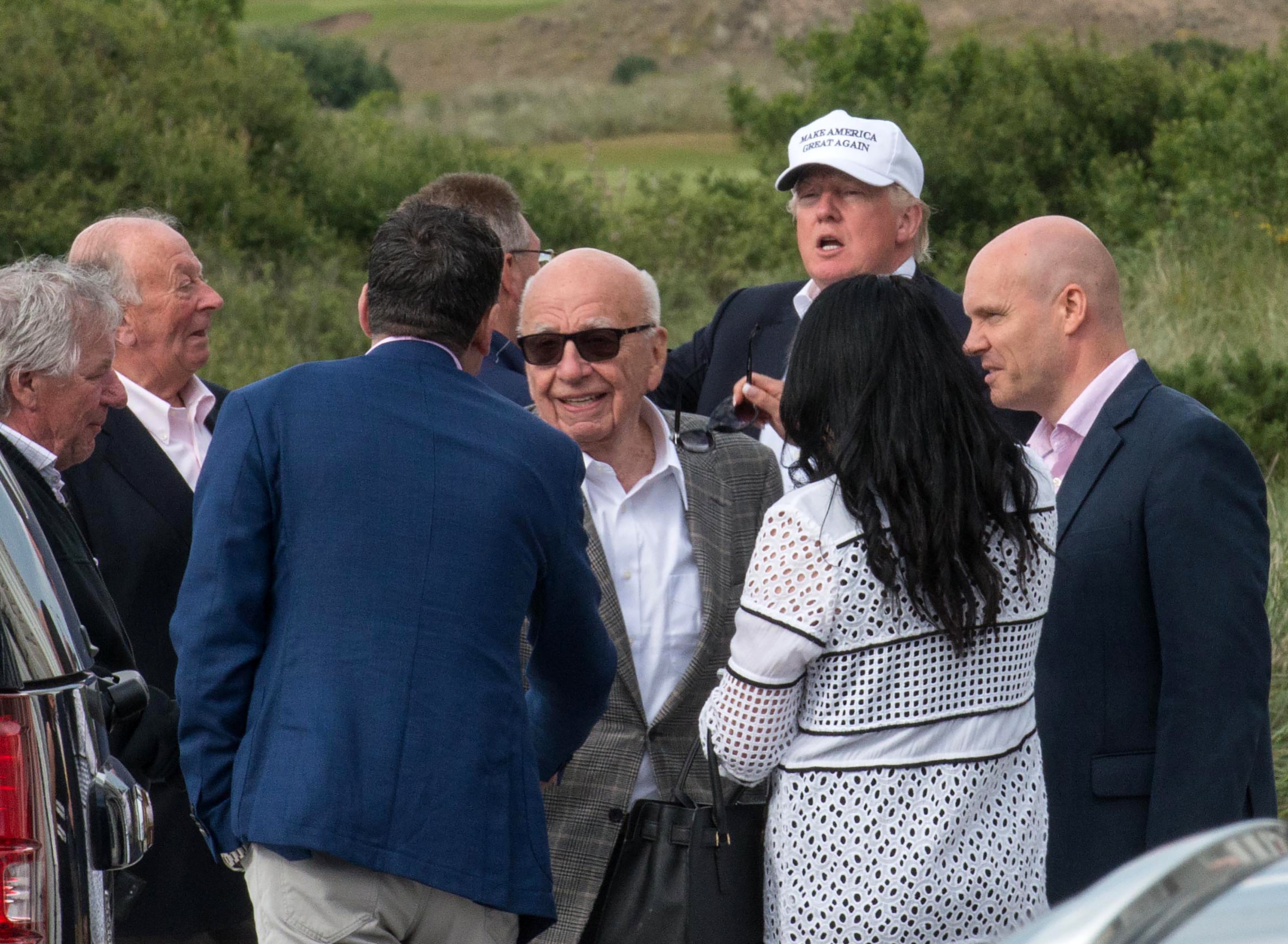 Presumptive Republican presidential nominee Donald Trump (2nd R) leaves with Australian born media magnate Rupert Murdoch (C) after a tour of his International Golf Links course north of Aberdeen on the east coast of Scotland on June 25, 2016