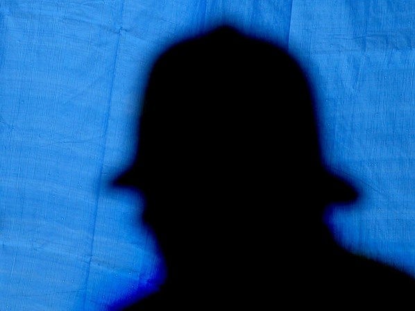 A silhouette of a police officer at a crime scene in London, 2003