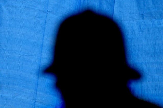 <p>A silhouette of a police officer at a crime scene in London, 2003</p>