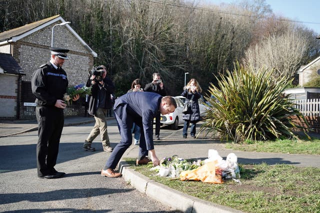 <p>Metropolitan Police Detective Superintendent Lewis Basford (centre) and Sussex Police Chief Superintendent James Collis (left) pay their respects at a tribute on Golf Drive in Brighton, East Sussex, near to where remains have been found in the search for the two-month-old baby of Constance Marten and Mark Gordon</p>