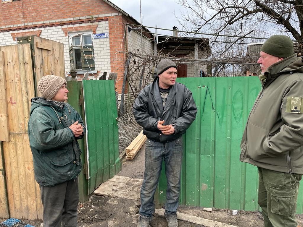 Aleksandr Osadchy, right, questions neighbours Natalya and Yuri Zdozovets