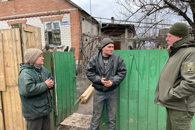 <p>Aleksandr Osadchy, right, questions neighbours Natalya and Yuri Zdozovets</p>