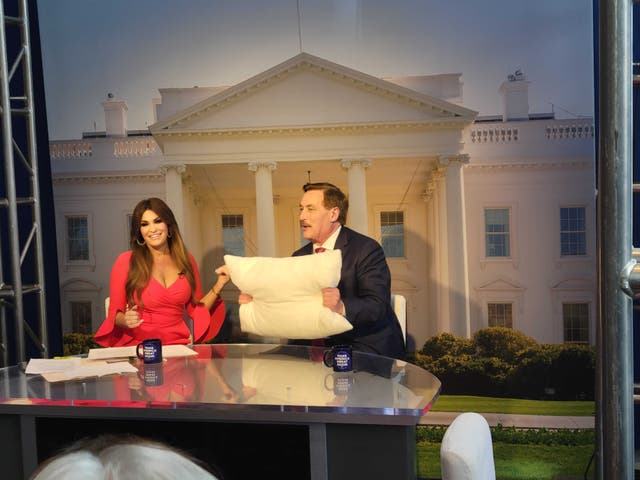 <p>Mike Lindell holds up a MyPillow product as he is interviewed by Kimberly Guilfoyle at CPAC</p>