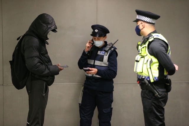 A man is issued with a fine for not wearing a face mask in London in 2020 (Jonathan Brady/PA)