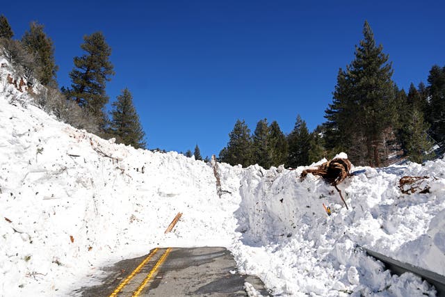 <p>Debris from an avalanche blocks California State Route 38 after a series of snow storms on 2nd March near Big Bear, California. San Bernardino County has declared a state of emergency as communities remain buried after a series of blizzards shut down all roads into the mountains, leaving the area running low on gas, food and supplies</p>