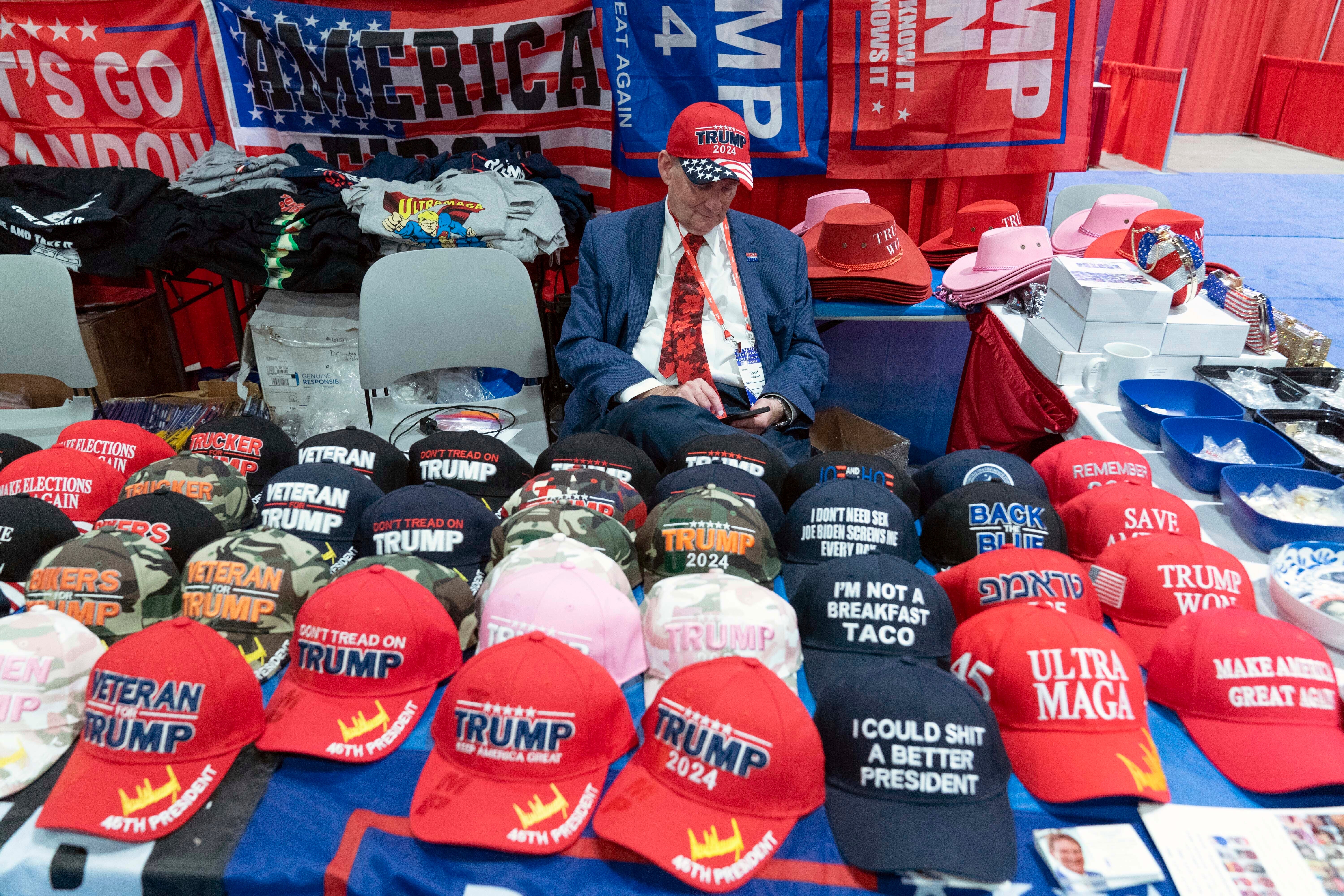 A man in a booth selling hats at CPAC 2023, at the National Harbor, in Oxon Hill, Maryland