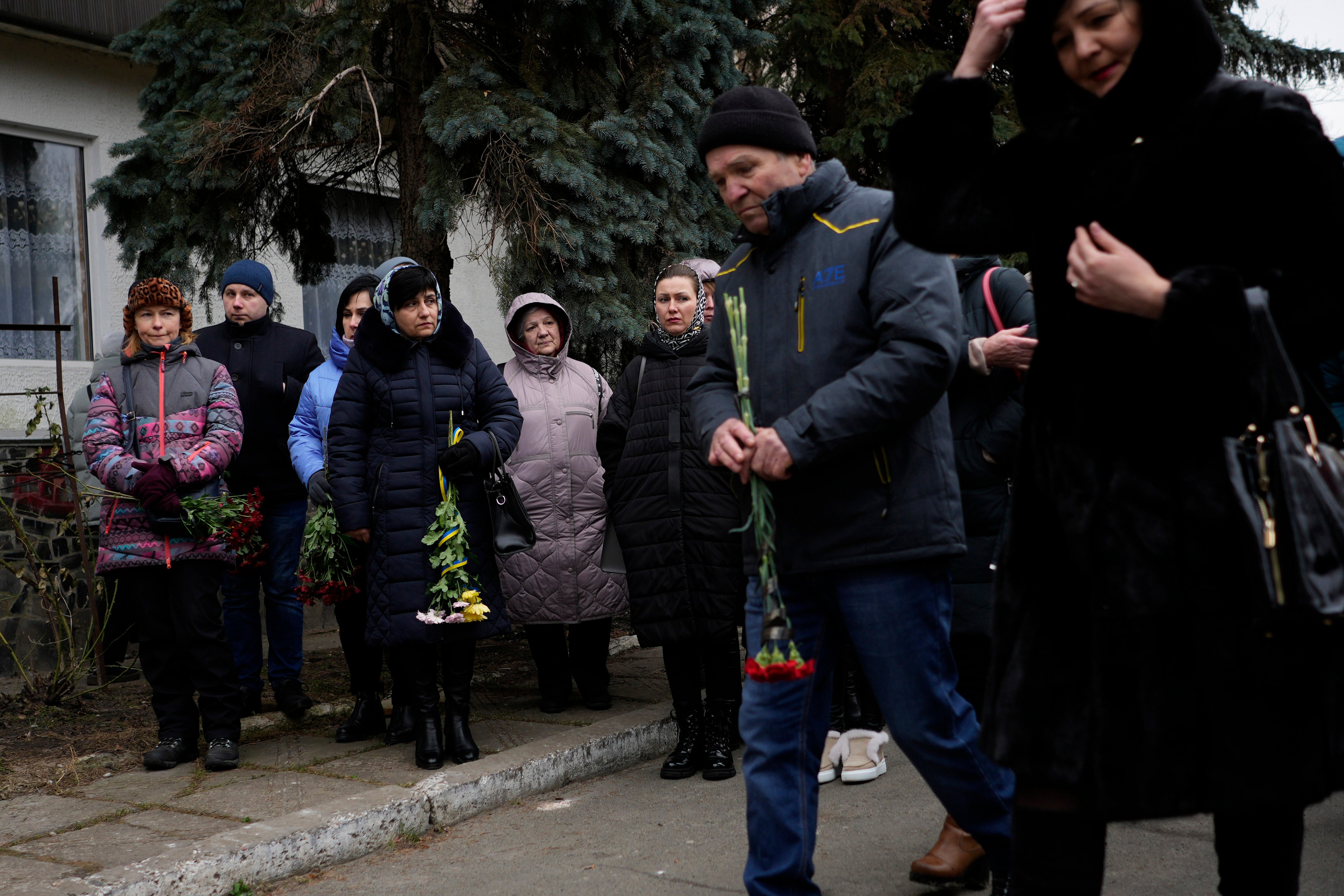 People attend a gathering to mark the first anniversary of the death of eight men killed by Russian forces in Bucha