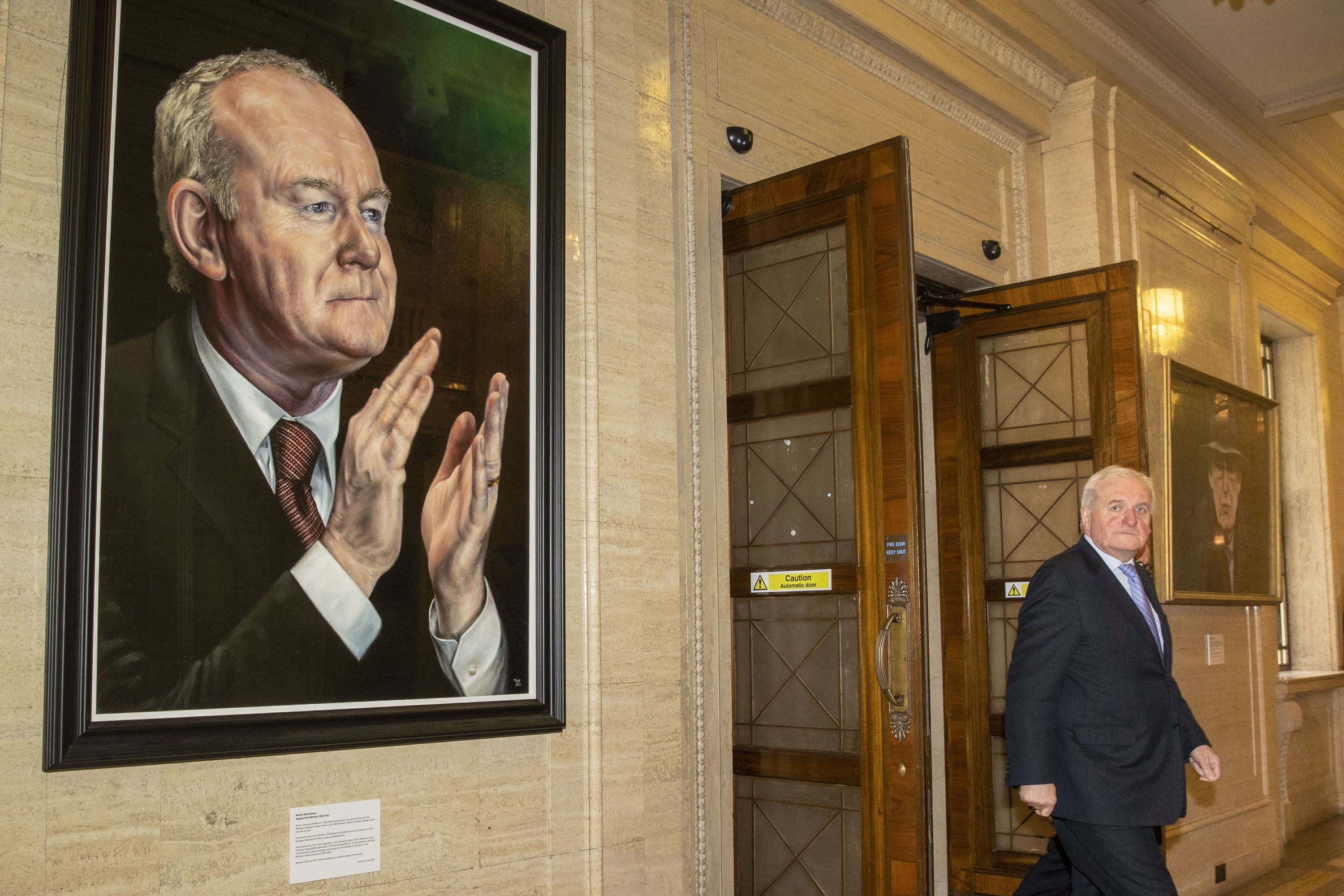 Former Taoiseach Bertie Ahern passes between portraits of former deputy first minister Martin McGuiness (left) and former first minister Ian Paisley during a meeting of the British-Irish Parliamentary Assembly Plenary (Liam McBurney/PA)