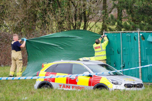 Firefighters erect screens at the scene in the St Mellons area of Cardiff where three people who disappeared on a night out have died in a road traffic accident. Two others who had also been reported missing have been transported to hospital with serious injuries. Sophie Russon, 20, Eve Smith, 21, and Darcy Ross, 21, who had made the trip from Porthcawl, and Rafel Jeanne, 24, and Shane Loughlin, 32, both from Cardiff, had last been seen in the city in the early hours of Saturday (Ben Birchall/PA)