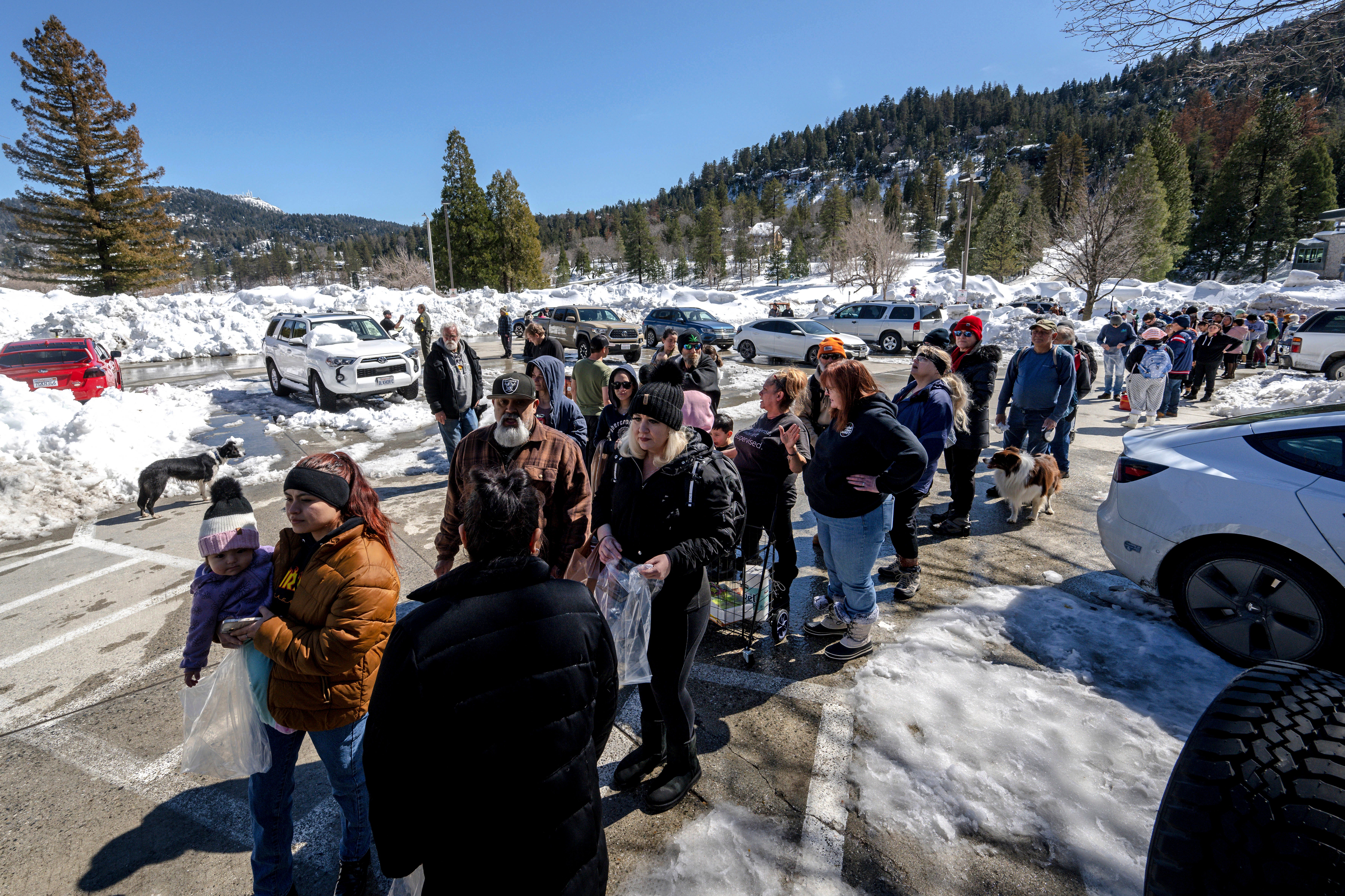 San Bernardino Mountain residents line up for a chance to get food at a tent in front of the Goodwin & Son's Market in Crestline on Friday