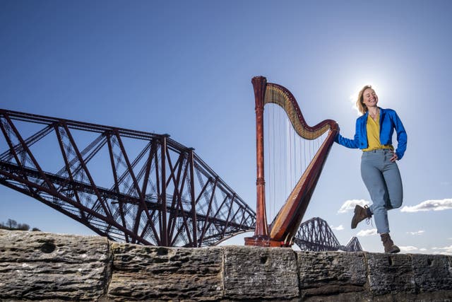 Composer, harpist and singer Esther Swift alongside her Italian Salvi pedal harp during a photocall ahead of her upcoming tour, at the Forth Bridge in North Queensferry (Jane Barlow/PA)
