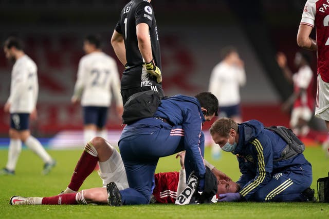 Arsenal’s Rob Holding is treated by the medical team before leaving the game as a concussion substitution (John Walton/PA)