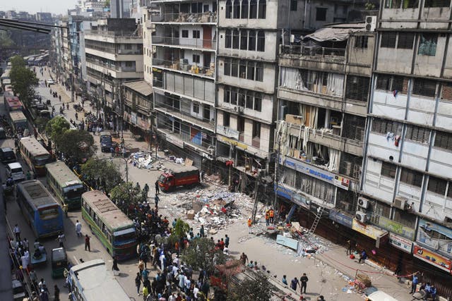 <p>Firefighters and emergency teams work amid debris a day after an explosion inside a building in Dhaka on 8 March</p>