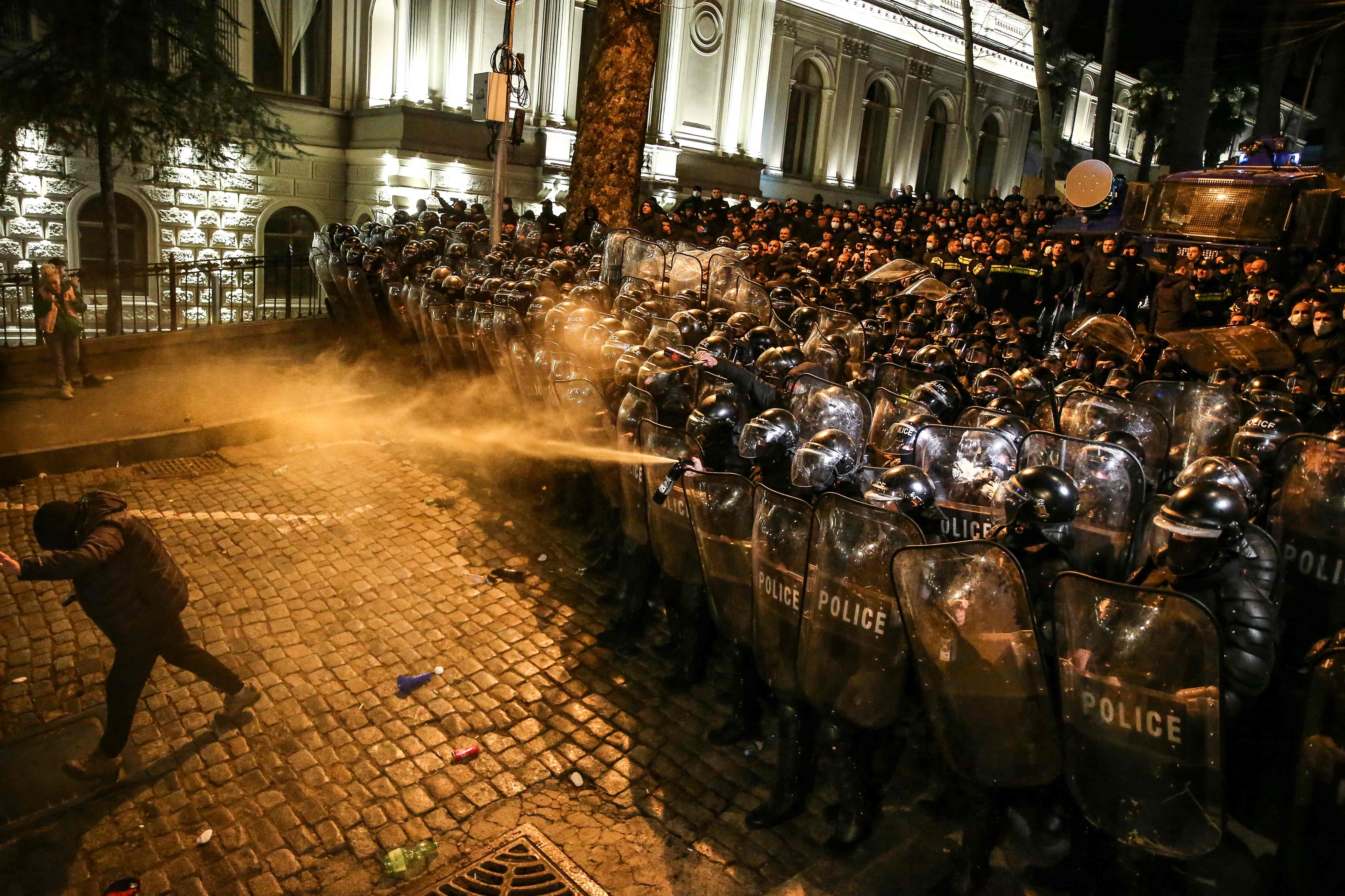 Riot police spray teargas towards a protester in Tbilisi