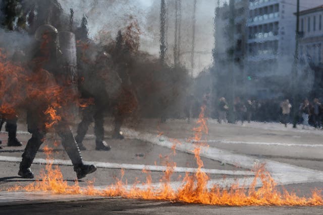 <p>Riot police avoid the flames of a molotov cocktail outside the Greek parliament in Athens on Wednesday</p>