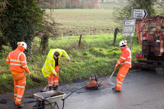 A road works team repairs a pothole in Buckingham
