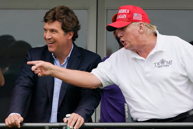<p>Tucker Carlson, left, and former President Donald Trump, talk while watching golfers on the 16th tee during the final round of the LIV Golf Invitational at Trump National in Bedminster, N.J., July 31, 2022</p>