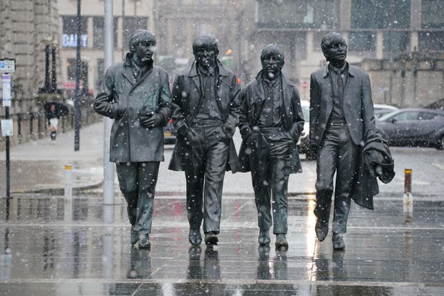 Snow falls around the Beatles statue in Liverpool (Peter Byrne/PA)