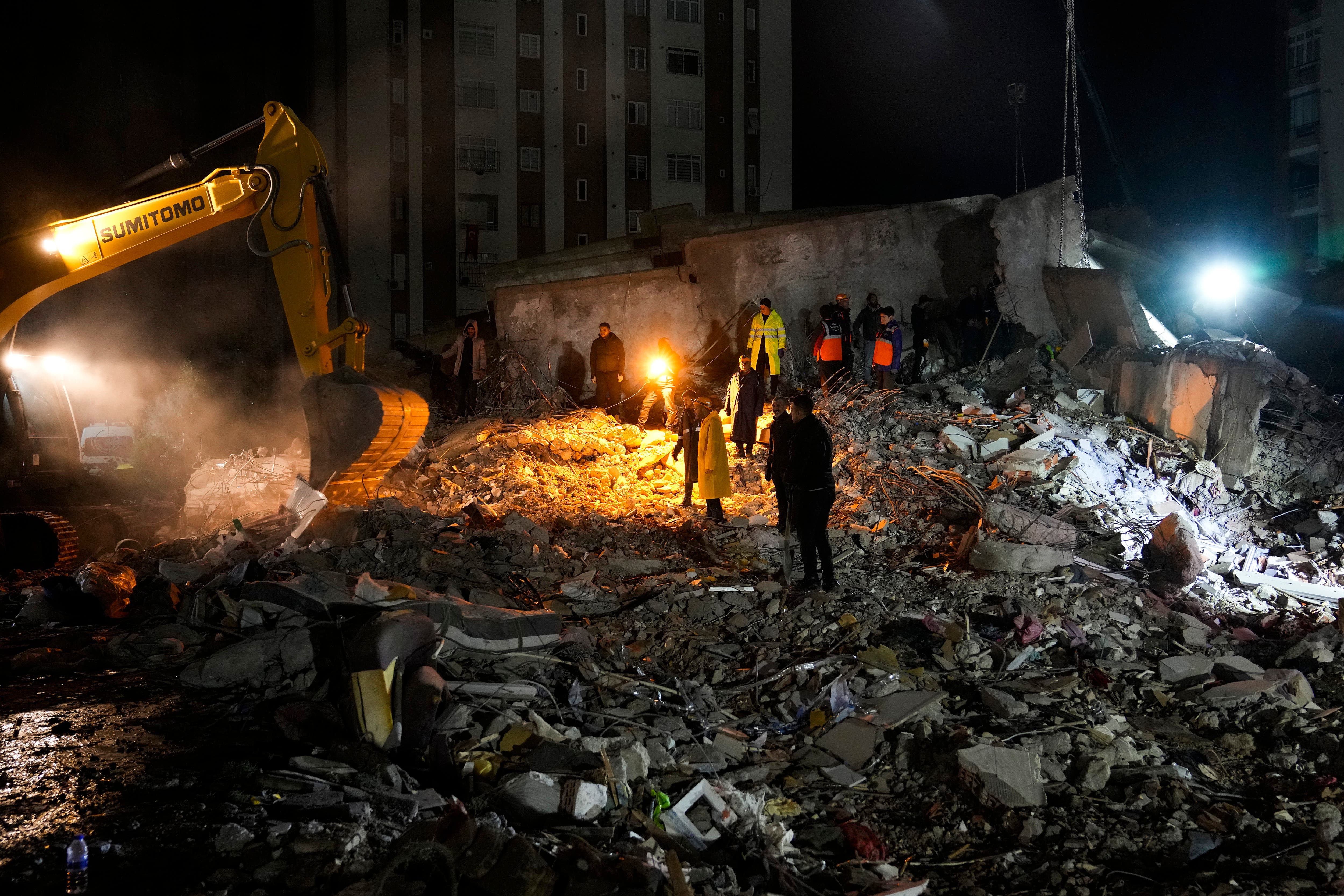 Emergency teams search through the rubble in Adana, Turkey (Khalil Hamra/AP)