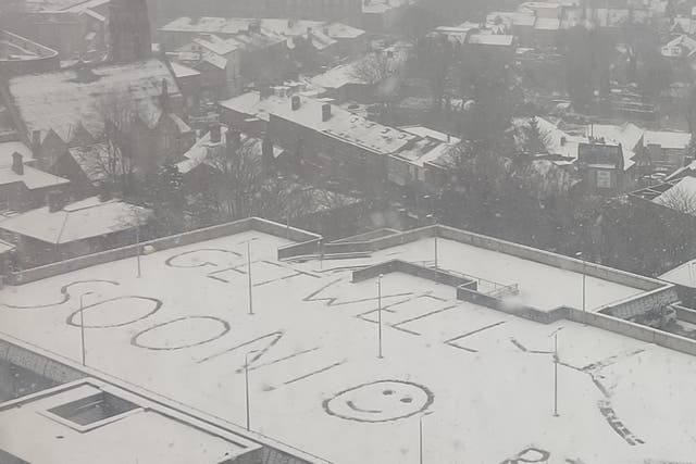 <p>A message written on top of a car park in the snow outside Royal Hallamshire Hospital </p>