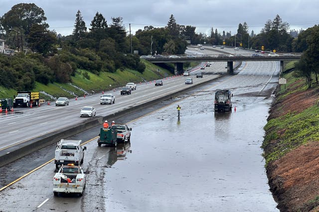 <p>Caltrans crews work by a flooded section of Interstate 580 in Oakland, California on Friday. A new atmospheric river has brought heavy rain and thunderstorms to California, bringing flood threats and disrupting travel</p>