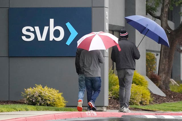 People walk past a Silicon Valley Bank sign at the company’s headquarters in California (AP Photo/Jeff Chiu)