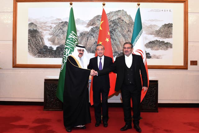 <p>Ali Shamkhani, the secretary of Iran's Supreme National Security Council, right, shakes hands with Saudi national security adviser Musaad bin Mohammed al-Aiban, left, as Wang Yi, China's most senior diplomat, looks on</p>