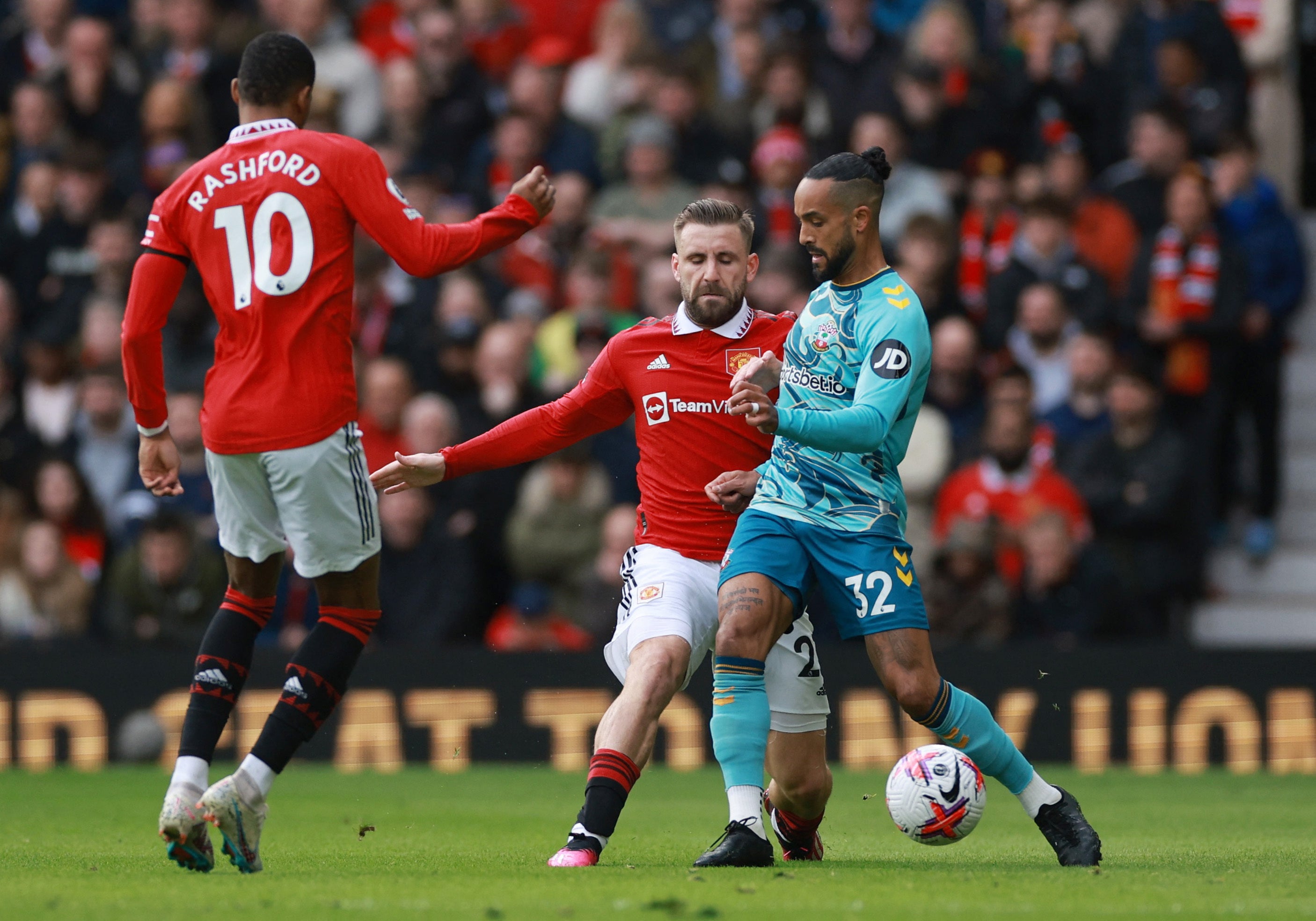 Luke Shaw challenges Theo Walcott in the early stages