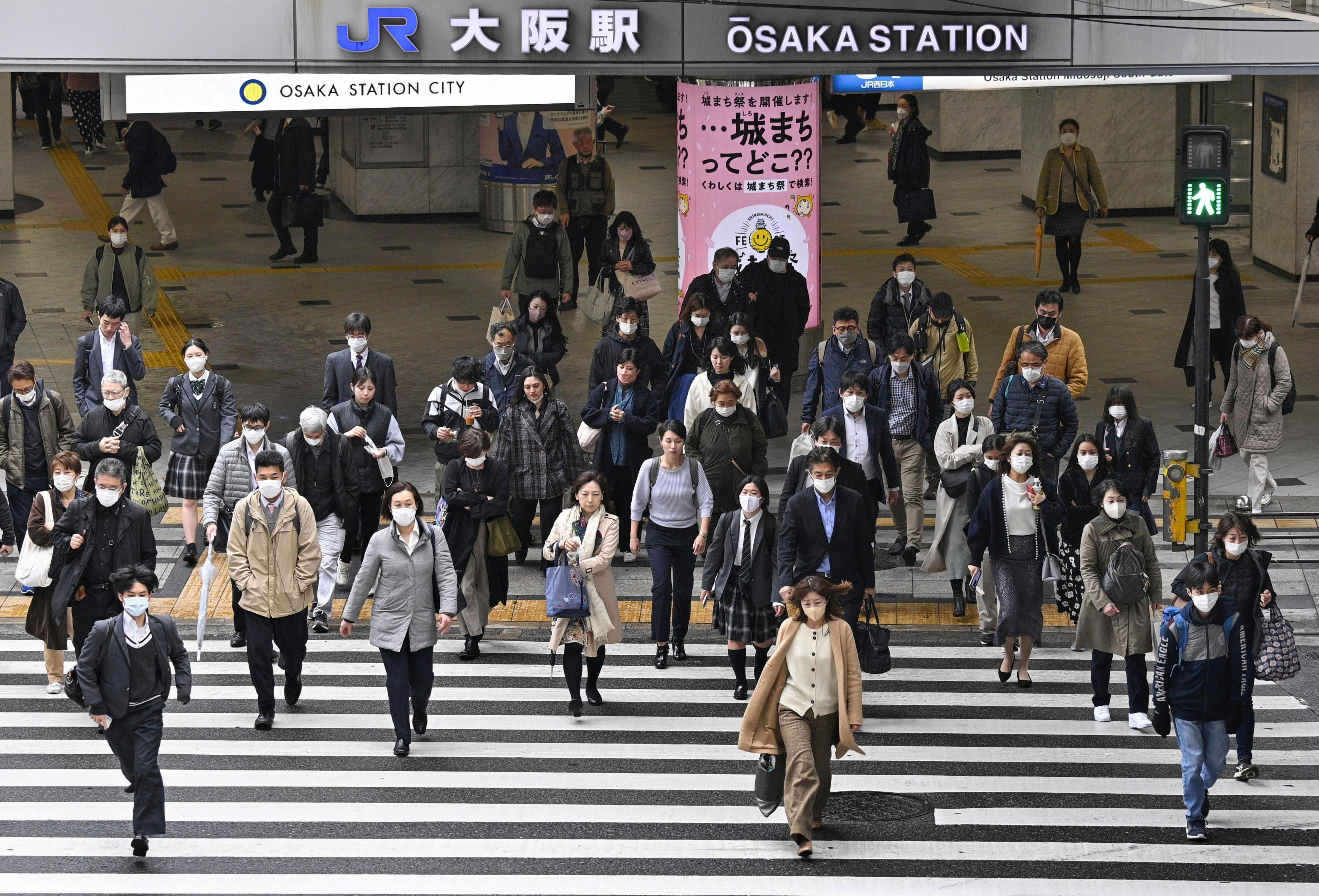 File photo: People walk across an intersection in Osaka, western Japan, Monday, 13 March 2023