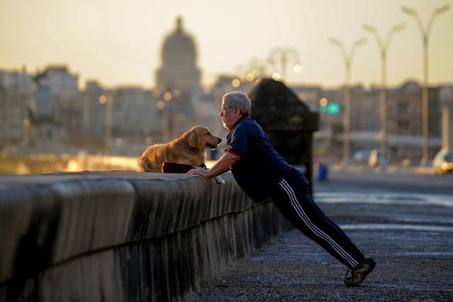 <p>A man exercises with his dog on the Malecon, Havana’s boardwalk, on April 19, 2018</p>