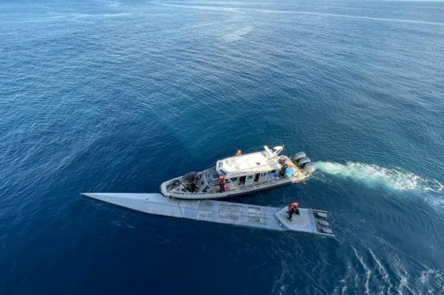 <p>A Colombian navy vessel pulls alongside a submarine allegedly used to transport cocaine to Central America</p>