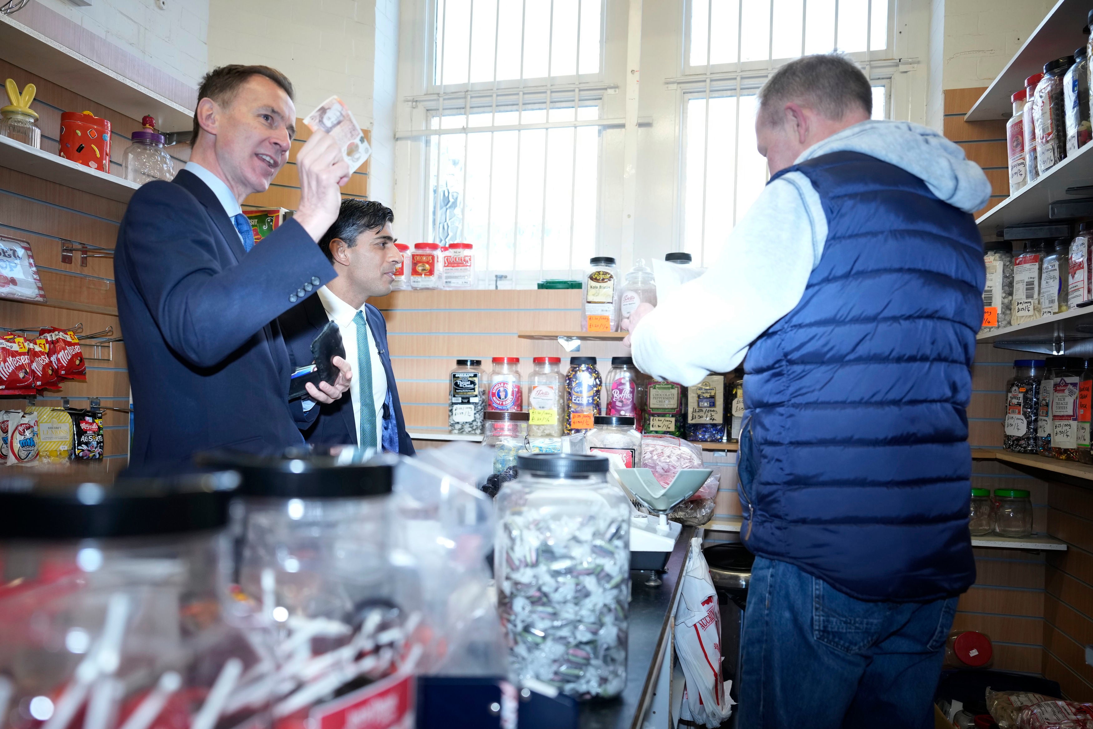 Chancellor Jeremy Hunt and Rishi Sunak purchase sweets during a community project visit