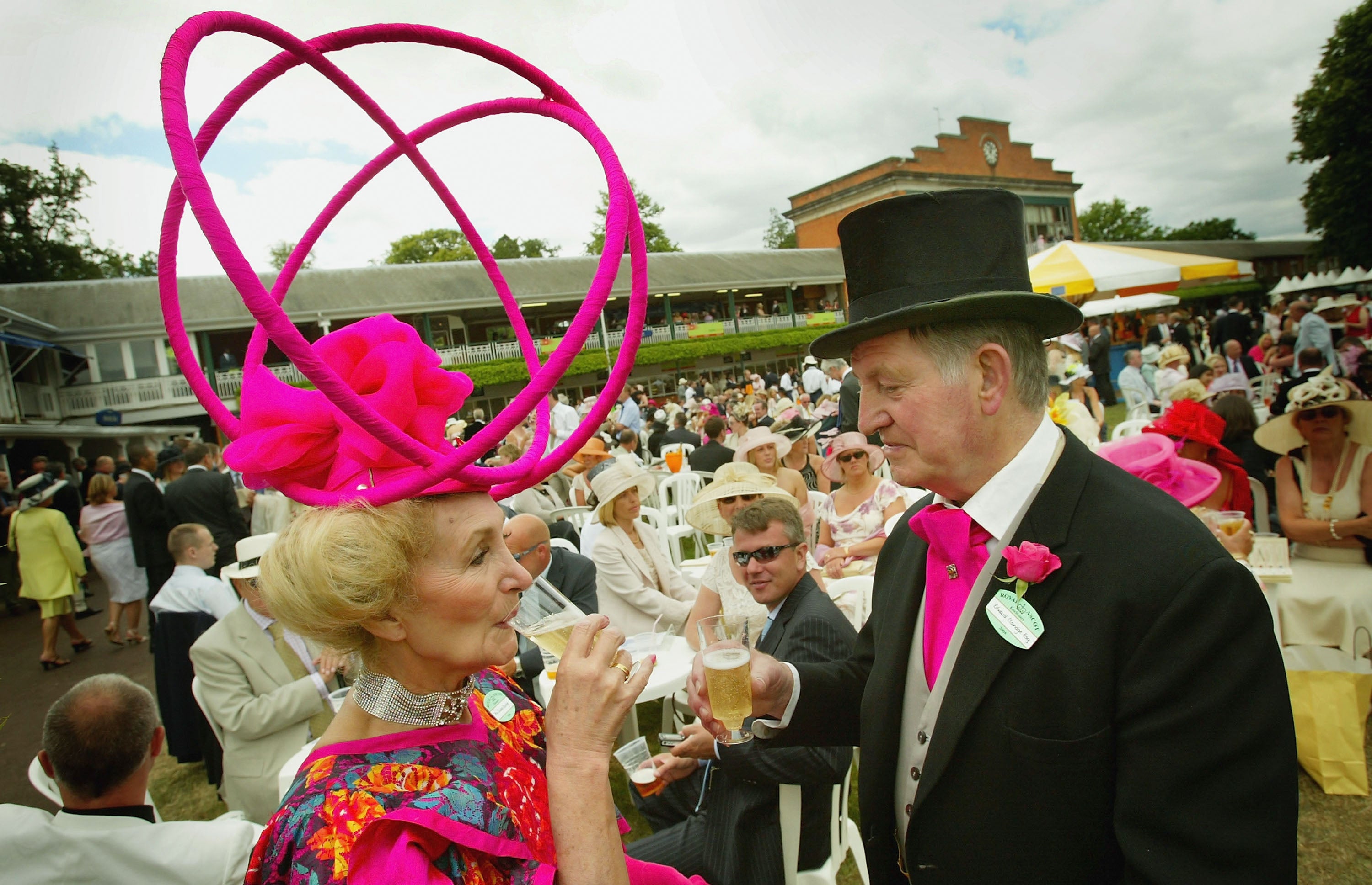 A couple drink champagne during Ladies Day on the third day of Royal Ascot at the Ascot Racecourse on June 17, 2004