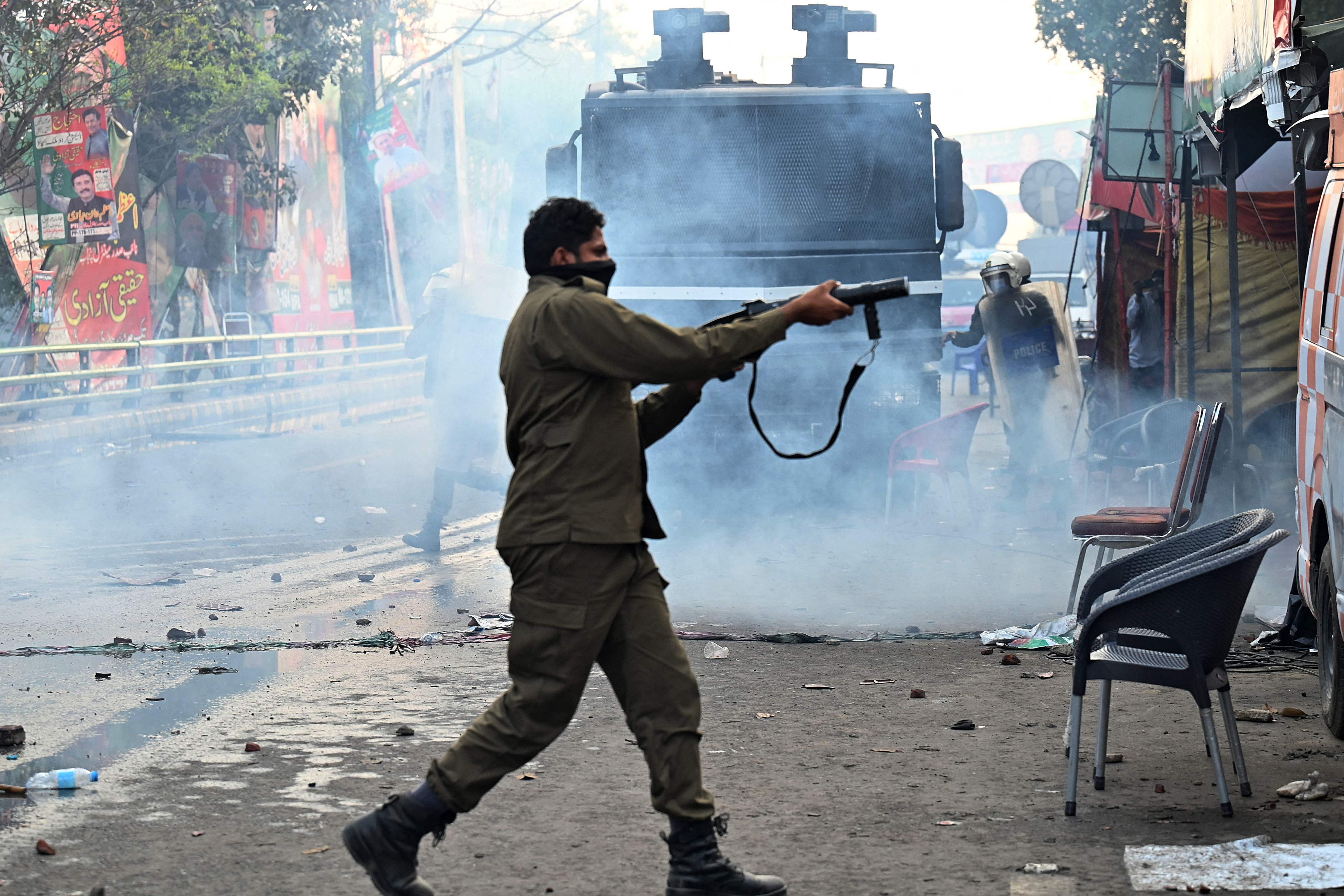 <p>Riot police fire teargas shells to push back supporters of Imran Khan gathered outside his house on Tuesday</p>
