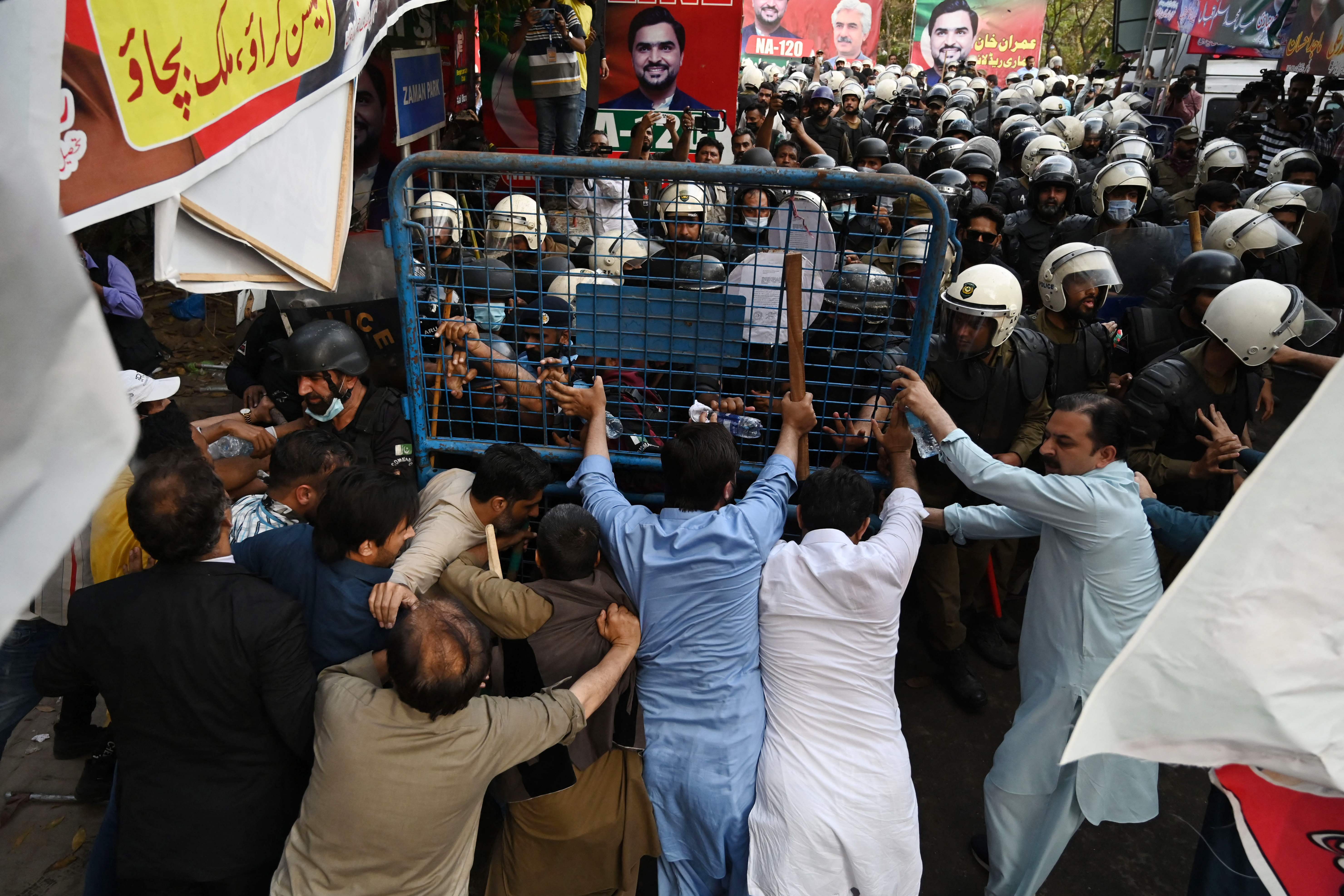 Supporters of Imran Khan and riot police scuffle outside Khan’s house in Lahore on Tuesday