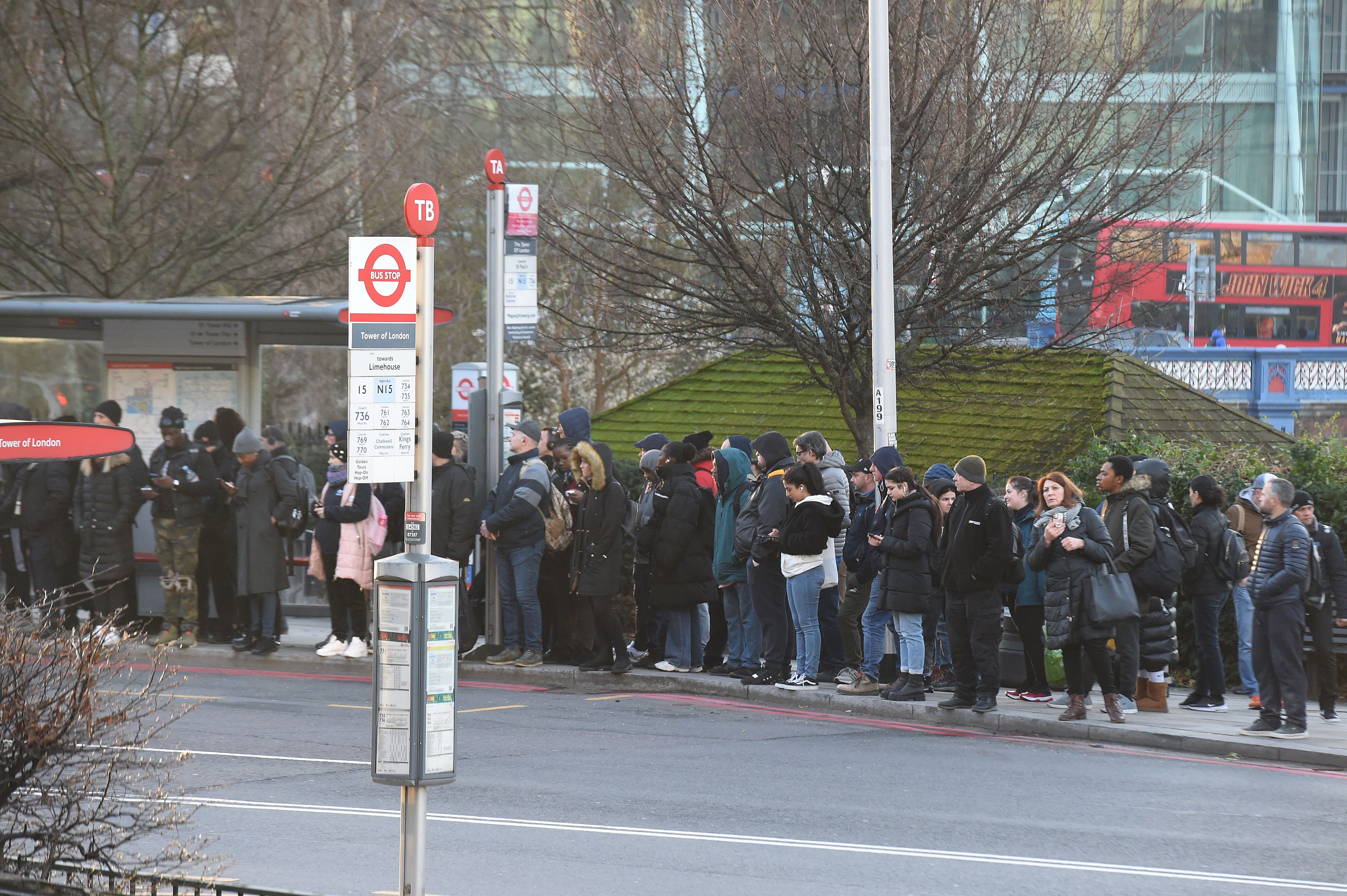 Commuters wait for a bus at Tower Hill